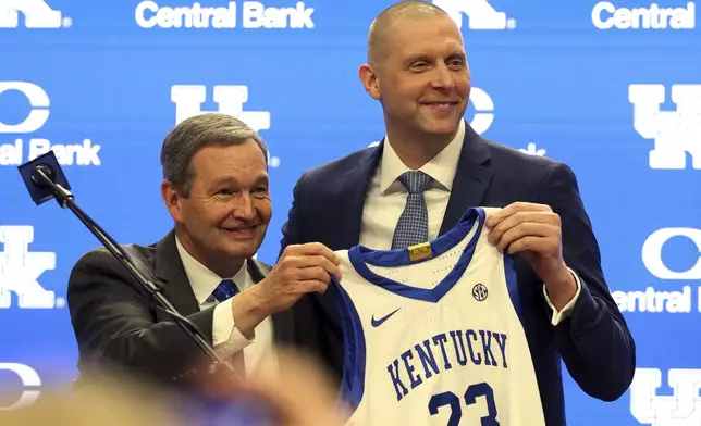 Kentucky Athletic Director Mitch Barnhart, left, and Mark Pope hold up a jersey after Pope was named head coach of the Kentucky men's basketball team in Lexington, Ky., Sunday, April 14, 2024. (AP Photo/James Crisp)