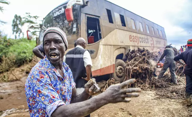 People try to clear a bus that was washed away after a dam burst in Kamuchiri Village Mai Mahiu, Nakuru County, Kenya, Monday, April. 29, 2024. Kenya's Interior Ministry says at least 45 people have died and dozens are missing after a dam collapsed following heavy rains. (AP Photo/Patrick Ngugi)
