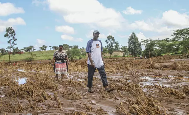 People walk through an area swept away after a dam burst in Kamuchiri Village Mai Mahiu, Nakuru County, Kenya, Monday, April. 29, 2024. Kenya's Interior Ministry says at least 45 people have died and dozens are missing after a dam collapsed following heavy rains. (AP Photo/Patrick Ngugi)