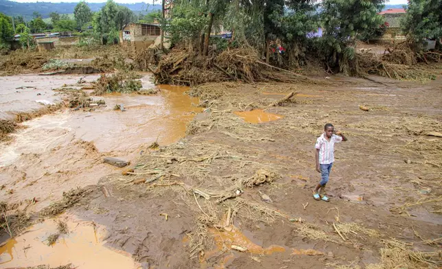 A child walk through an area swept away after a dam burst in Kamuchiri Village Mai Mahiu, Nakuru County, Kenya, Monday, April. 29, 2024. Kenya's Interior Ministry says at least 45 people have died and dozens are missing after a dam collapsed following heavy rains. (AP Photo/Patrick Ngugi)