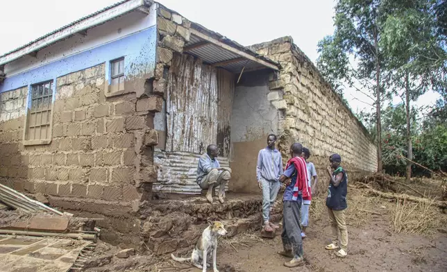 People gather near a damaged house after a dam burst in Kamuchiri Village Mai Mahiu, Nakuru County, Kenya, Monday, April. 29, 2024. Kenya's Interior Ministry says at least 45 people have died and dozens are missing after a dam collapsed following heavy rains. (AP Photo/Patrick Ngugi)
