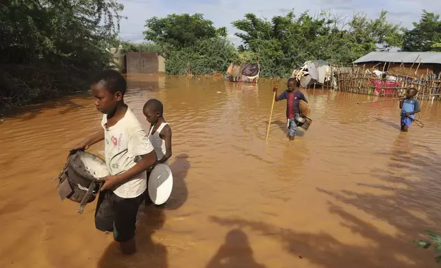 Children fleeing floodwaters that wreaked havoc at Mororo, border of Tana River and Garissa counties, North Eastern Kenya, Sunday, April 28, 2024. The East African country has seen weeks of heavy rains and severe flooding in Kenya’s capital, Nairobi, as well as in the country's western and central regions. (AP Photo/Andrew Kasuku)