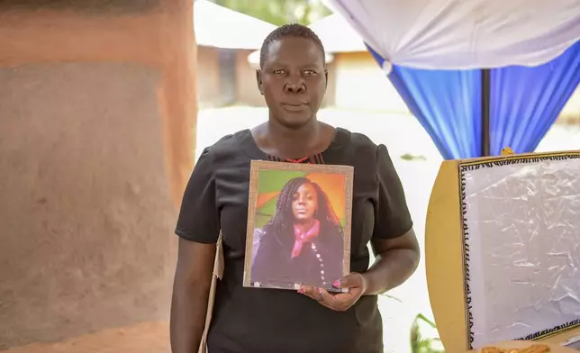 Winnie Akinyi, elder sister to Rose Bella Awuor, 31 years, holds her late sister's portrait ahead of her burial in Awendo, Migori County, Kenya Thursday, April. 11, 2024. Awuor fell ill in December and lost her five-month pregnancy before succumbing to malaria. It was the latest of five deaths in this family attributed to malaria. The disease is endemic to Kenya and is preventable and curable, but poverty makes it deadly for those who can't afford treatment. (AP Photo/Brian Ongoro)