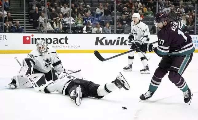 Los Angeles Kings defenseman Drew Doughty, bottom, blocks a shot by Anaheim Ducks left wing Alex Killorn (17) during the first period of an NHL hockey game Tuesday, April 9, 2024, in Anaheim, Calif. (AP Photo/William Liang)