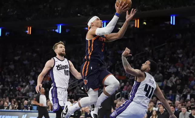 New York Knicks' Josh Hart (3) drives against Sacramento Kings' Domantas Sabonis (10) and Trey Lyles (41) during the first half of an NBA basketball game Thursday, April 4, 2024, in New York. (AP Photo/Frank Franklin II)