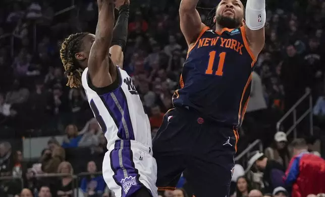New York Knicks' Jalen Brunson, right, shoots next to Sacramento Kings' Keon Ellis during the first half of an NBA basketball game Thursday, April 4, 2024, in New York. (AP Photo/Frank Franklin II)
