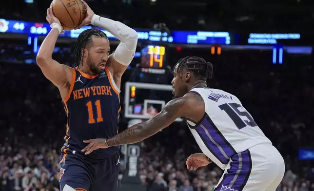 New York Knicks' Jalen Brunson (11) protects the ball from Sacramento Kings' Davion Mitchell (15) during the first half of an NBA basketball game Thursday, April 4, 2024, in New York. (AP Photo/Frank Franklin II)
