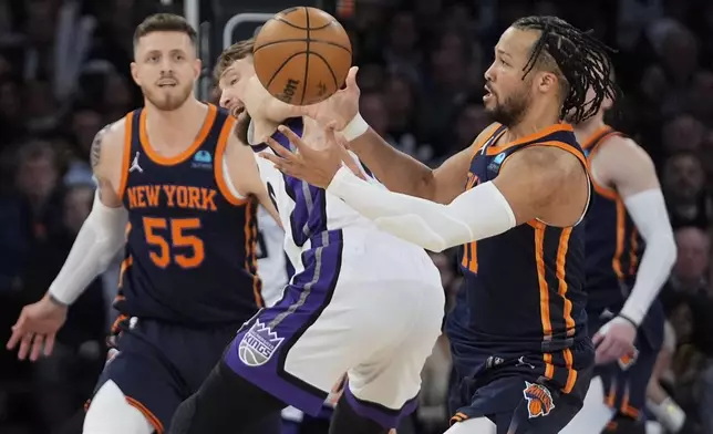 New York Knicks' Jalen Brunson, right, steals the ball from Sacramento Kings' Domantas Sabonis during the first half of an NBA basketball game Thursday, April 4, 2024, in New York. (AP Photo/Frank Franklin II)