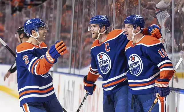 Edmonton Oilers' Evan Bouchard (2), Connor McDavid (97) and Zach Hyman (18) celebrate a goal against the Los Angeles Kings during the second period of Game 2 of an NHL hockey Stanley Cup first-round playoff series Wednesday, April 24, 2024, in Edmonton, Alberta. (Jason Franson/The Canadian Press via AP)