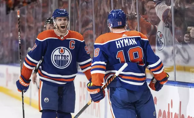 Edmonton Oilers' Connor McDavid (97) and Zach Hyman (18) celebrate a goal against the Los Angeles Kings during the second period of Game 2 of an NHL hockey Stanley Cup first-round playoff series Wednesday, April 24, 2024, in Edmonton, Alberta. (Jason Franson/The Canadian Press via AP)