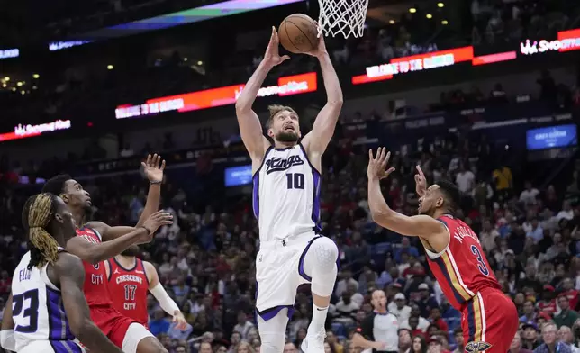 Sacramento Kings forward Domantas Sabonis (10) goes to the basket over New Orleans Pelicans guard CJ McCollum (3) in the first half of an NBA basketball play-in tournament game in New Orleans, Friday, April 19, 2024. (AP Photo/Gerald Herbert)