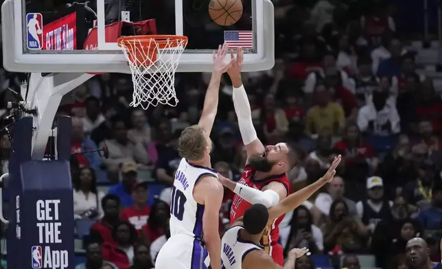 New Orleans Pelicans center Jonas Valanciunas shoots against Sacramento Kings forward Domantas Sabonis (10) in the first half of an NBA basketball play-in tournament game in New Orleans, Friday, April 19, 2024. (AP Photo/Gerald Herbert)