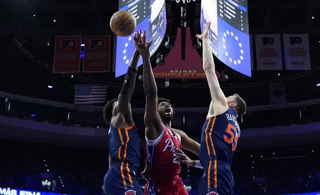 Philadelphia 76ers' Joel Embiid, center, cannot get a shot past New York Knicks' OG Anunoby, left, and Isaiah Hartenstein during the first half of Game 4 in an NBA basketball first-round playoff series, Sunday, April 28, 2024, in Philadelphia. (AP Photo/Matt Slocum)