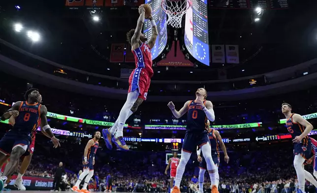 Philadelphia 76ers' Kelly Oubre Jr., left, goes up for a dunk as New York Knicks' Donte DiVincenzo looks on during the first half of Game 4 in an NBA basketball first-round playoff series, Sunday, April 28, 2024, in Philadelphia. (AP Photo/Matt Slocum)