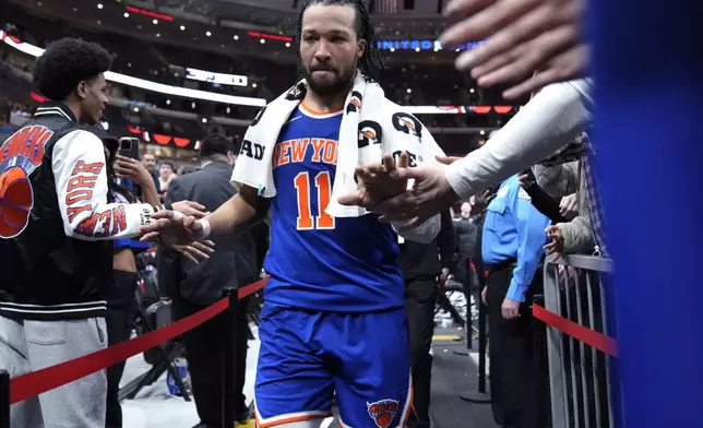 New York Knicks guard Jalen Brunson celebrates with fans as he leaves the court after the Knicks defeated the Chicago Bulls in an NBA basketball game in Chicago, Tuesday, April 9, 2024. (AP Photo/Nam Y. Huh)