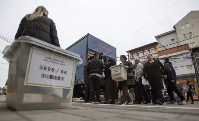 Kosovo election officials unload the ballot boxes and polling station materials in North Mitrovica, Kosovo Sunday, April 21, 2024. Residents of four Serb-majority municipalities are casting their votes Sunday in a referendum to decide whether to remove their ethnic Albanian mayors from office following last year’s mayoral elections, overwhelmingly boycotted by the Serb minority. (AP Photo/Visar Kryeziu)