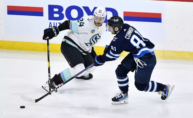 Winnipeg Jets' Kyle Connor (81) skates past Seattle Kraken's Jamie Oleksiak (24) during the third period of an NHL hockey game in Winnipeg, Manitoba on Tuesday April 16, 2024. (Fred Greenslade/The Canadian Press via AP)