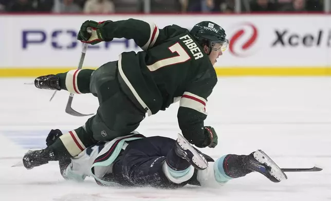 Minnesota Wild defenseman Brock Faber (7) and Seattle Kraken right wing Eeli Tolvanen collide during the second period of an NHL hockey game Thursday, April 18, 2024, in St. Paul, Minn. (AP Photo/Abbie Parr)