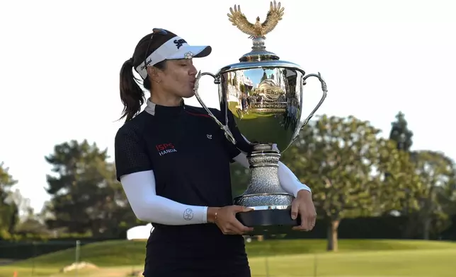 Hannah Green kisses the championship trophy after winning the LPGA's JM Eagle LA Championship golf tournament at Wilshire Country Club, Sunday, April 28, 2024, in Los Angeles. (AP Photo/Ashley Landis)