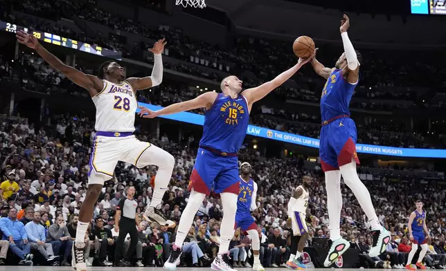 Denver Nuggets center Nikola Jokic (15) and Peyton Watson. right, reach for a rebound against Los Angeles Lakers forward Rui Hachimura (28) during the first half in Game 1 of an NBA first-round playoff series Saturday, April 20, 2024, in Denver. (AP Photo/Jack Dempsey)