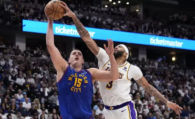 Los Angeles Lakers forward Anthony Davis (3) gets a hand on the ball against Denver Nuggets center Nikola Jokic (15) during the second half in Game 1 of an NBA basketball first-round playoff series Saturday, April 20, 2024, in Denver. (AP Photo/Jack Dempsey)