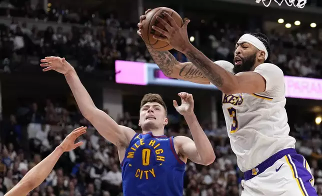 Los Angeles Lakers forward Anthony Davis (3) grabs a rebound against Denver Nuggets guard Christian Braun (0) during the second half in Game 1 of an NBA basketball first-round playoff series Saturday, April 20, 2024, in Denver. (AP Photo/Jack Dempsey)