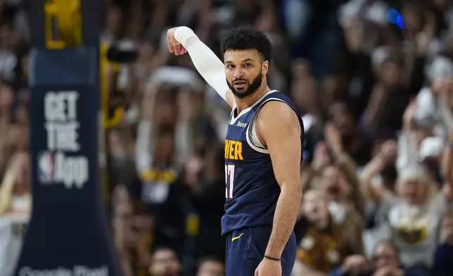 Denver Nuggets guard Jamal Murray looks back at the Los Angeles Lakers bench after hitting a 3-point basket late in the second half of Game 5 of an NBA basketball first-round playoff series Monday, April 29, 2024, in Denver. (AP Photo/David Zalubowski)