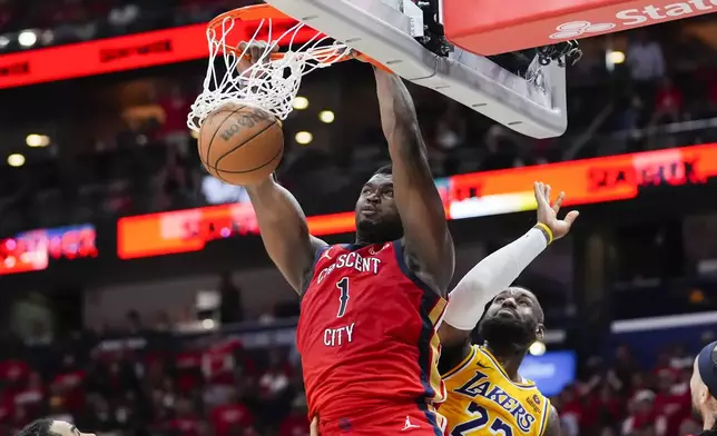 New Orleans Pelicans forward Zion Williamson (1) slam dunks over Los Angeles Lakers forward LeBron James (23) in the second half of an NBA basketball play-in tournament game Tuesday, April 16, 2024, in New Orleans. The Lakers won 110-106. (AP Photo/Gerald Herbert)