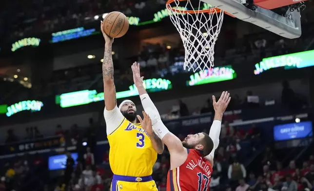 Los Angeles Lakers forward Anthony Davis (3) shoots against New Orleans Pelicans center Jonas Valanciunas (17) in the first half of an NBA basketball play-in tournament game Tuesday, April 16, 2024, in New Orleans. (AP Photo/Gerald Herbert)