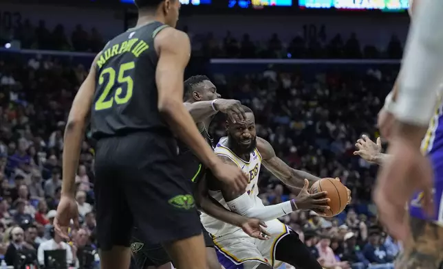 Los Angeles Lakers forward LeBron James (23) drives to the basket against New Orleans Pelicans forward Zion Williamson and guard Trey Murphy III (25) in the first half of an NBA basketball game in New Orleans, Sunday, April 14, 2024. (AP Photo/Gerald Herbert)