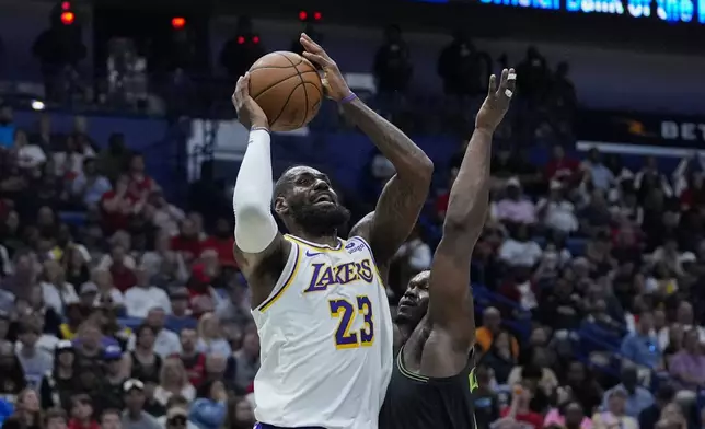 Los Angeles Lakers forward LeBron James (23) shoots against New Orleans Pelicans forward Zion Williamson in the first half of an NBA basketball game in New Orleans, Sunday, April 14, 2024. (AP Photo/Gerald Herbert)