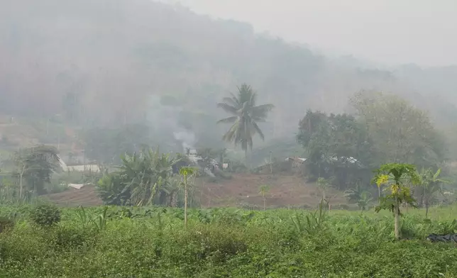 Smoke from trash burning in a village outside the Lao UNESCO heritage site of Luang Prabang joins the heavy haze over much of inland Southeast Asia due to crop and waste burning, Saturday, April 6, 2024. ASEAN finance ministers met in Luang Prabang this week to discuss economic and financial issues including ways to help finance reductions in carbon emissions that contribute to global warming. (AP Photo/Elaine Kurtenbach)