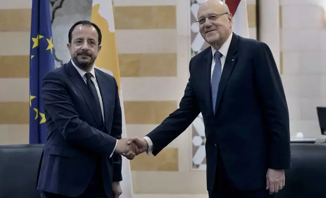 Cyprus' President Nikos Christodoulides, left, shakes hands with Lebanese caretaker Prime Minister Najib Mikati at the government headquarters in Beirut, Lebanon, Monday, April 8, 2024. Christodoulides' visit to Beirut comes after he asked the European Union last week to intervene with Lebanese authorities to stop boatloads of Syrian refugees from heading to the east Mediterranean island nation. Lebanon's caretaker prime minister asked Southern European countries along the Mediterranean Sea to pressure the European Union to help Lebanon deport undocumented migrants. (AP Photo/Bilal Hussein)