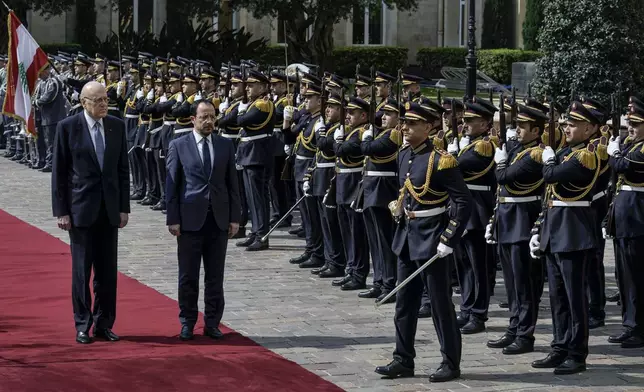 Cyprus' President Nikos Christodoulides, on carpet right, attends a military welcome ceremony with Lebanese caretaker Prime Minister Najib Mikati,on carpet left, upon his arrival to the government headquarters in Beirut, Lebanon, Monday, April 8, 2024. Christodoulides' visit to Beirut comes after he asked the European Union last week to intervene with Lebanese authorities to stop boatloads of Syrian refugees from heading to the east Mediterranean island nation. Lebanon's caretaker prime minister asked Southern European countries along the Mediterranean Sea to pressure the European Union to help Lebanon deport undocumented migrants. (AP Photo/Bilal Hussein)