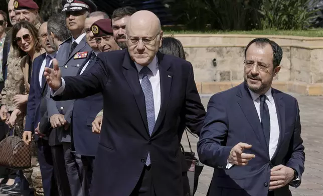 Cyprus' President Nikos Christodoulides, right, and Lebanese caretaker Prime Minister Najib Mikati, left, arrive at the government headquarters in Beirut, Lebanon, Monday, April 8, 2024. Christodoulides' visit to Beirut comes after he asked the European Union last week to intervene with Lebanese authorities to stop boatloads of Syrian refugees from heading to the east Mediterranean island nation. Lebanon's caretaker prime minister asked Southern European countries along the Mediterranean Sea to pressure the European Union to help Lebanon deport undocumented migrants. (AP Photo/Bilal Hussein)
