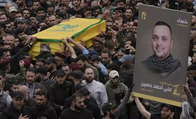 Hezbollah fighters carry the coffin of their comrade, Ali Ahmad Hussein, who was killed by an Israeli strike in south Lebanon, during his funeral procession in the southern Beirut suburb of Dahiyeh, Lebanon, Monday, April 8, 2024. Israel's military says it has killed a commander of Hezbollah's secretive Radwan Force in southern Lebanon. (AP Photo/Bilal Hussein)