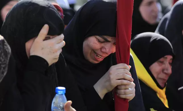 Mourners react during the funeral of Ismail Baz, a Hezbollah commander and another fighter who were killed on Tuesday by an Israeli drone strike, in Chehabiyeh village, south Lebanon, Wednesday, April 17, 2024. The Israeli military said Baz served as a senior and veteran official in several positions of Hezbollah's military wing. (AP Photo/Mohammed Zaatari)