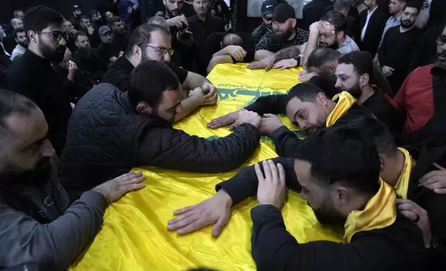Mourners grieve over the coffin of, Ali Ahmad Hussein, who was killed by an Israeli strike in south Lebanon, during his funeral procession in the southern Beirut suburb of Dahiyeh, Lebanon, Monday, April 8, 2024. Israel's military says it has killed a commander of Hezbollah's secretive Radwan Force in southern Lebanon. (AP Photo/Bilal Hussein)