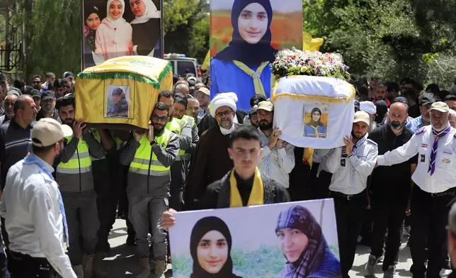 Hezbollah civil defense and Al-Mahdi scout carry the coffins of Mariam Kashakesh, left, and her 10-year-old niece Sarah Kashakesh who were killed on Tuesday by an Israeli airstrike, during their funeral procession in Hanine village, south Lebanon, Thursday, April 25, 2024. Hezbollah militants and Israeli forces have been exchanging fire since a day after the Israel-Hamas war began on Oct. 7. (AP Photo/Mohammed Zaatari)