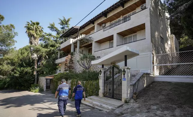 Municipal police officers patrol outside a villa where the Lebanese money changer Mohammad Srour, 57, was found tortured and killed in Monte Verdi neighbourhood of Beit Meri, Lebanon, Tuesday, April 16, 2024. Lebanon’s interior minister alleged Wednesday that the mysterious abduction and killing of a Hezbollah-linked Lebanese financier in a villa on the edge of a quiet mountain resort town earlier this month was likely the work of Israeli operatives. (AP Photo/Hassan Ammar)
