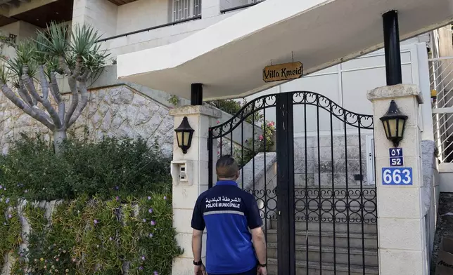 A municipal police officer stands outside a villa where the Lebanese money changer Mohammad Srour, 57, was found tortured and killed in Monte Verdi neighborhood of Beit Meri, Lebanon, Tuesday, April 16, 2024. Lebanon’s interior minister alleged Wednesday that the mysterious abduction and killing of a Hezbollah-linked Lebanese financier in a villa on the edge of a quiet mountain resort town earlier this month was likely the work of Israeli operatives. (AP Photo/Hassan Ammar)
