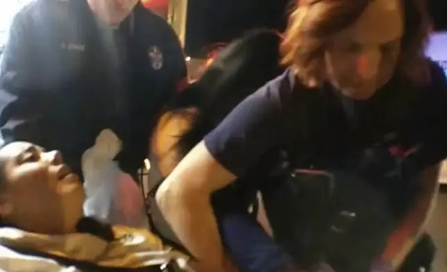 In this image from El Paso County Sheriff's Office body-camera video, Jerica LaCour is restrained on a gurney in Colorado Springs, Colo., on Jan. 11, 2018. "Guess who gets ketamine?" paramedic Jason Poulson of AMR, the nation's largest ambulance company, said. AMR and Poulson deny responsibility for LaCour’s death in her family’s pending lawsuit, arguing LaCour was experiencing excited delirium and ketamine was appropriate. (El Paso County Sheriff's Office via AP)