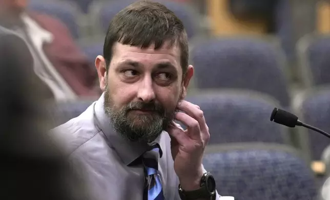 Sean Hodgson, a member of the U.S. Army Reserve, shows where he was punched by Robert Card while giving testimony, Thursday, April 25, 2024, in Augusta, Maine, during a hearing of the independent commission investigating the law enforcement response to the mass shooting in Lewiston, Maine. (AP Photo/Robert F. Bukaty)