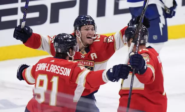 Florida Panthers defenseman Oliver Ekman-Larsson (91) left wing Matthew Tkachuk (19) and center Aleksander Barkov, right, celebrate after Barkov scored during the third period of Game 5 of the first-round of an NHL Stanley Cup Playoff series against the Tampa Bay Lightning, Monday, April 29, 2024, in Sunrise, Fla. (AP Photo/Wilfredo Lee)