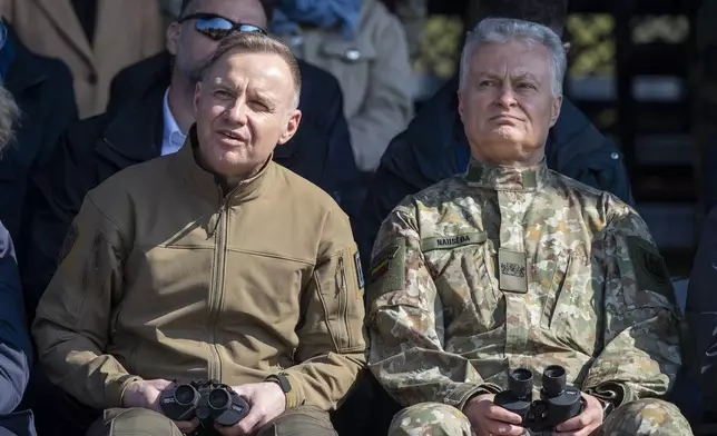 Poland's President Andrej Duda, left, and Lithuania's President Gitanas Nauseda sit together to watch a Lithuanian-Polish Brave Griffin 24/II military exercise near the Suwalki Gap near the Polish border at the Dirmiskes village, Alytus district west of the capital Vilnius in Lithuania on Friday, April 26, 2024. Over 1500 troops and 200 pieces of tactical equipment are rehearsing defence scenarios under the bilateral Lithuanian-Polish Orsha Plan near the Suwalki Gap. (AP Photo/Mindaugas Kulbis)