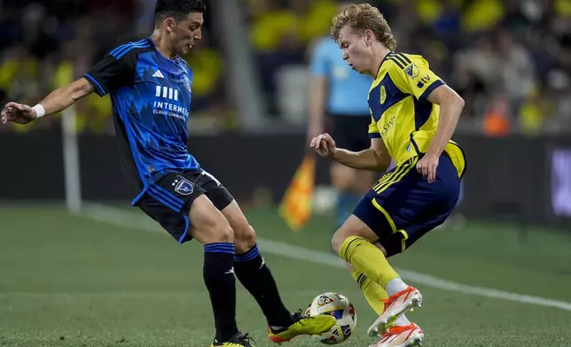 San Jose Earthquakes forward Cristian Espinoza (10) kicks the ball away from Nashville SC midfielder Jacob Shaffelburg (14) during the second half of an MLS soccer match Saturday, April 27, 2024, in Nashville, Tenn. The Earthquakes and Nashville played to a 1-1 draw. (AP Photo/George Walker IV)