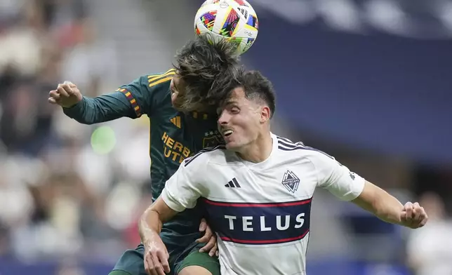 LA Galaxy's Miki Yamane, left, and Vancouver Whitecaps' Alessandro Schopf collide while vying for the ball during the first half of an MLS soccer match Saturday, April 13, 2024, in Vancouver, British Columbia. (Darryl Dyck/The Canadian Press via AP)