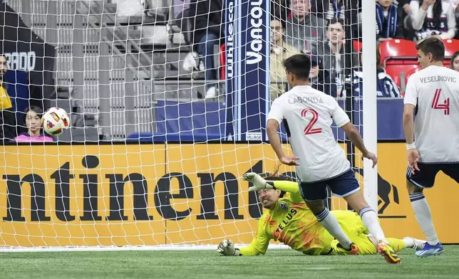 Vancouver Whitecaps goalkeeper Yohei Takaoka, back, allows a goal to LA Galaxy's Dejan Joveljic, not seen, as Vancouver's Mathias Laborda (2) and Ranko Veselinovic (4) watch during the second half of an MLS soccer match Saturday, April 13, 2024, in Vancouver, British Columbia. (Darryl Dyck/The Canadian Press via AP)