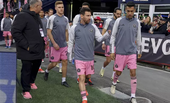 Inter Miami forward Lionel Messi, front center, waves to fans as he walks onto the field with teammates at Gillette Stadium before an MLS soccer match against the New England Revolution, Saturday, April 27, 2024, in Foxborough, Mass. (AP Photo/Mark Stockwell)