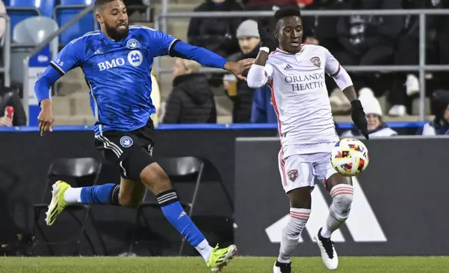 Orlando City's Ivan Angulo, right, breaks away from CF Montreal's George Campbell, left, during second-half MLS soccer match action in Montreal, Saturday, April 20, 2024. (Graham Hughes/The Canadian Press via AP)